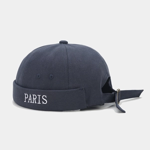 Detail of adjustable metal buckle and PARIS embroidery on navy blue docker hat