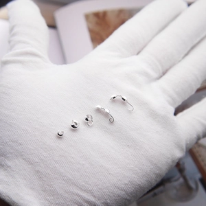 Makro-Detail von S925 Sterling Silber Crimpperlen und Schmuckverschlüssen auf der Hand