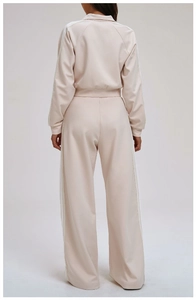 Rear view of beige sportswear tracksuit featuring white triple side stripes on jacket and pants