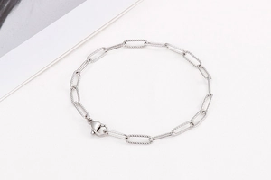 Detailed view of silver paperclip link bracelet with secure lobster clasp closure
