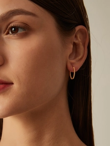 Close-up of minimalist 14K gold plated silver beaded hoop earring worn by a model