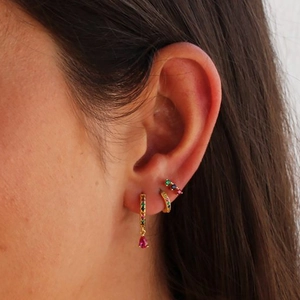Close-up of gold ear cuff set with red drop gem and colorful zircon stones on model