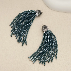 Close-up of dark green multi-strand beaded tassel earrings with crystal studded metal caps