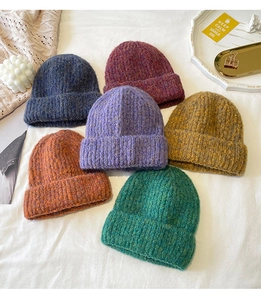 Detail of multi-colored thick knit beanies with textured wool blend for winter warmth