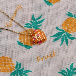 Gold plated heart pendant necklace with orange pink enamel and bee on patterned fabric