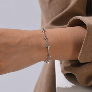 Detail shot of a silver starburst charm bracelet worn on a wrist for a stylish look