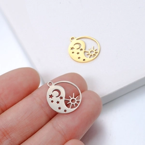 Golden and silver stainless steel sun moon star pendants shown for scale by hand