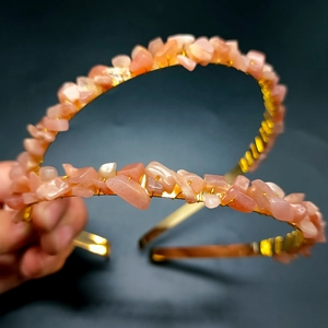 Close-up of handmade crown with pink raw crystal stones and golden wire weaving