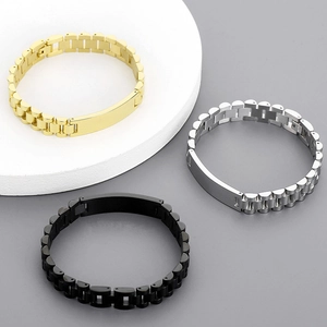 Detail of stainless steel link bracelets in gold, silver, and black finish on a white stand