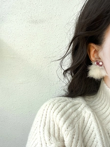 Detail of red checkered heart stud with white plush pompom on female model