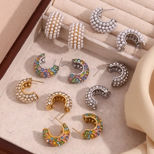 Assorted C-shape earrings with pearls and colorful crystals in a jewelry box