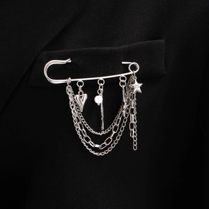 Broche épingle à nourrice argentée avec chaînes et breloques cœur et étoile sur veste