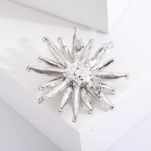 Detailed back view of a silver sunflower brooch showing the pin and clasp mechanism