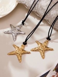 Vue détaillée de pendentifs d'étoiles de mer texturés en or et argent sur cordon