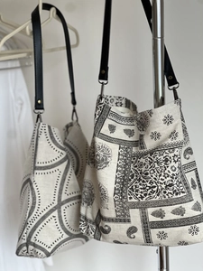 Detail of linen tote bag with black geometric paisley prints and leather strap