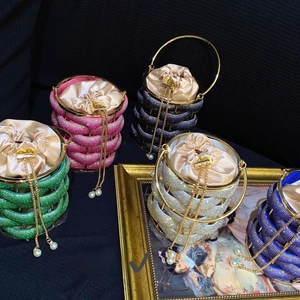 Detail of colorful rhinestone bucket bags with satin lining and pearl metal chain straps