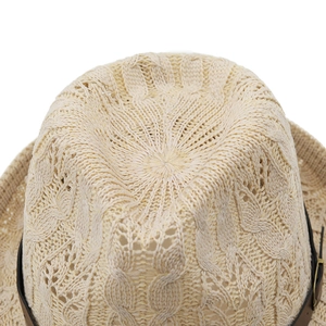 Close-up of beige straw hat featuring fine knit texture and dark leather band detail