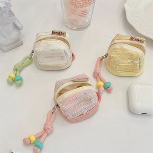 Close-up of cute tweed-textured portable earphone cases in various pastel colors.