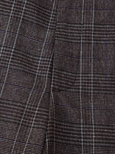 Vue macro du tissu tissé à carreaux marron montrant les coutures et le motif classique