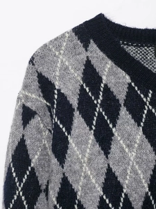 Close-up of the classic argyle pattern on a high-quality knit sweater in blue and grey