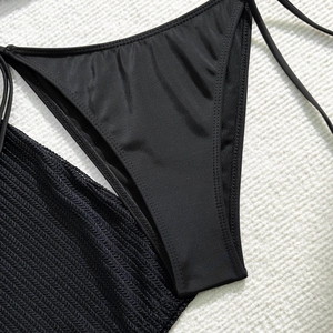 Macro detail of black tie-side bikini bottoms with high-stretch fabric and premium stitching