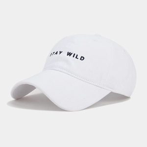 Dettaglio del berretto da baseball bianco con ricamo STAY WILD in filo nero