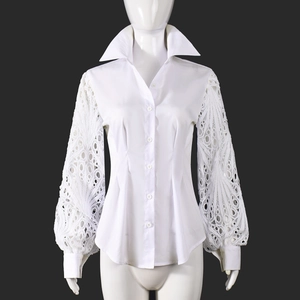 Detailed view of white long sleeve shirt featuring intricate lace hollow embroidery on lantern sleeves