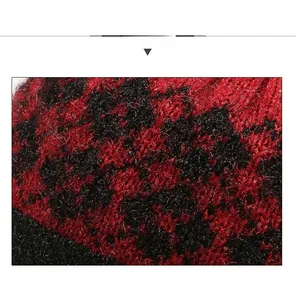 Detail view of the soft red and black checkered knit fabric with warm wool texture