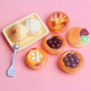 Detailed top view of 7-piece miniature bakery set with tiny pastries on pink background