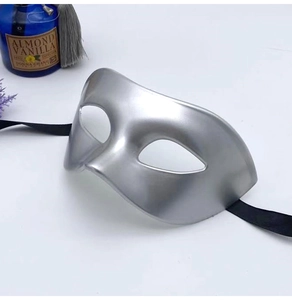 Close-up of silver masquerade half-mask with black ribbons and sleek metallic finish