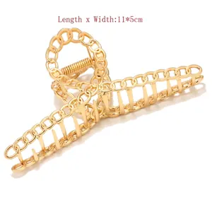 Detail view of large gold metal butterfly hair claw clip with chain design, 11x5cm size