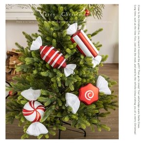 Detailed view of red and white striped Christmas candy ornaments hanging on a festive tree