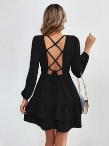 Détail d'une robe noire dos nu sexy avec lacets croisés et ourlet à volants superposés