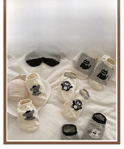 Flat lay of cotton no-show socks with cute cartoon animal embroidery in neutral colors