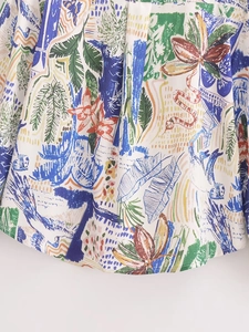 Close-up of lightweight woven fabric with colorful tropical leaf prints on white base