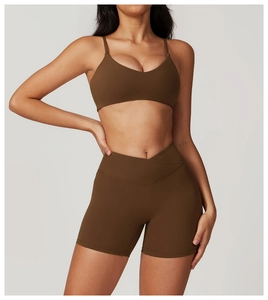 Detail of cross-over high waistband on brown recycled quick-dry yoga shorts and sports bra