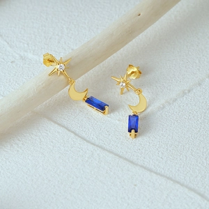 Detail of S925 silver gold-plated earring with blue crystal and engraved logo mark