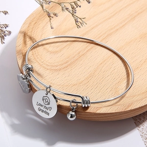 Adjustable steel wire bracelet with Love You Grandma pendant in wooden tray