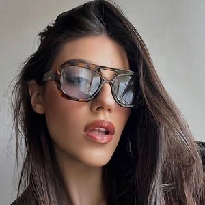 Classic double-bridge pilot sunglasses with tortoiseshell frame worn by a model