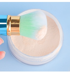 Gros plan des poils doux du pinceau prélevant de la poudre libre de maquillage fine