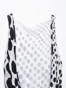 Detailed close-up of lightweight black and white polka dot chiffon fabric texture