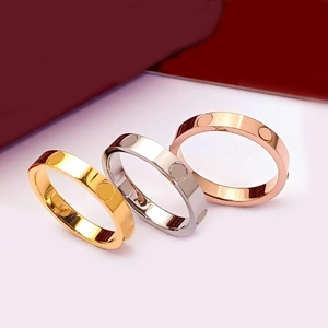Detailed view of three polished screw-motif bands in gold, silver, and rose gold finishes