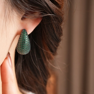 Détail de boucles d'oreilles vintage goutte d'eau vert émeraude pavées de zircons
