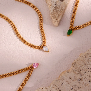Elegant gold Cuban link necklace featuring emerald, pink and clear pear-cut gemstones