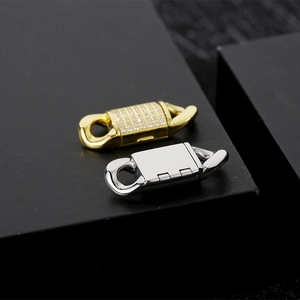 Detail of gold zircon-paved and silver polished stainless steel Cuban flip clasps