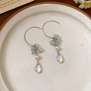 Vue détaillée de boucles d'oreilles feuilles en argent avec perles et pierres bleues