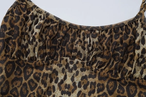Detail of leopard print mesh bodysuit featuring a U-neckline and delicate ruched fabric