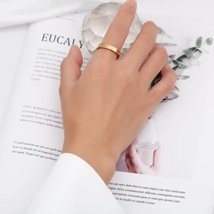 Polished rose gold heart ring with screw motifs worn by a model in a stylish setup