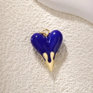 Detail of dark blue heart pendant with gold molten metal finish and glossy enamel texture
