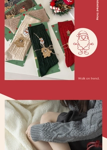 Detail showing cable knit Christmas socks with snowman embroidery and festive wreaths